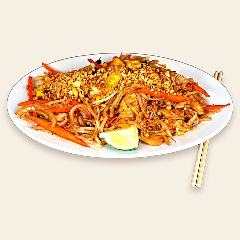 Pad Thai topped with crushed peanuts and a lime wedge