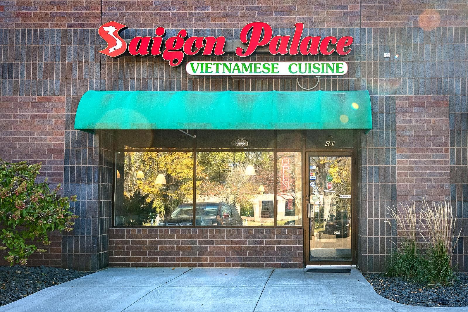 The Saigon Palace storefront: a red Saigon Palace sign over a green awning and glass front door